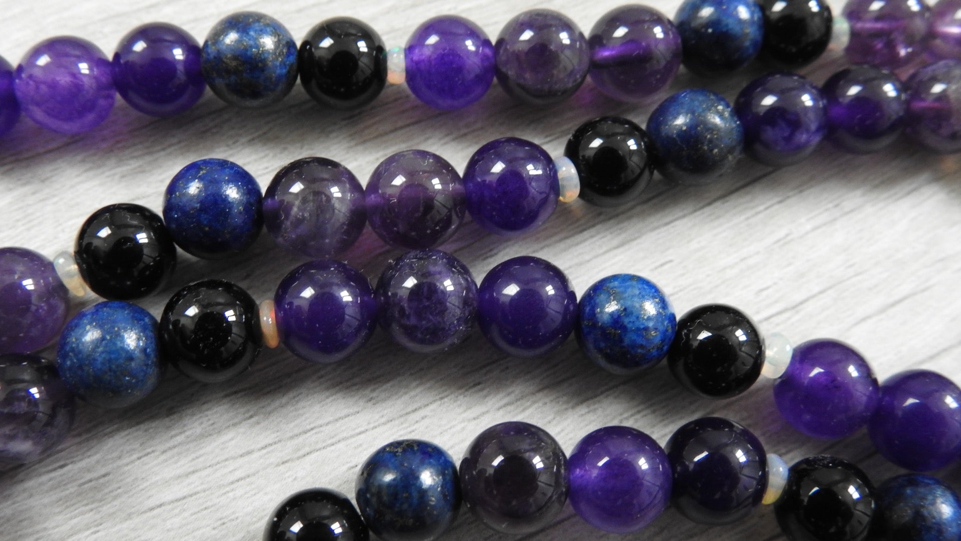 Angled view of one-of-a-kind dragon pendant showing three-dimensional sterling silver craftsmanship and mystical gemstone arrangement.