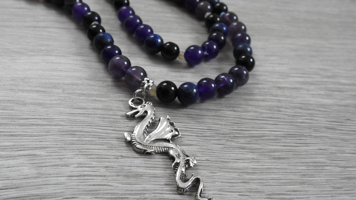 Handcrafted dragon pendant in sterling silver featuring blue lapis lazuli, amethyst, obsidian, and opal stones, front view against white background.
