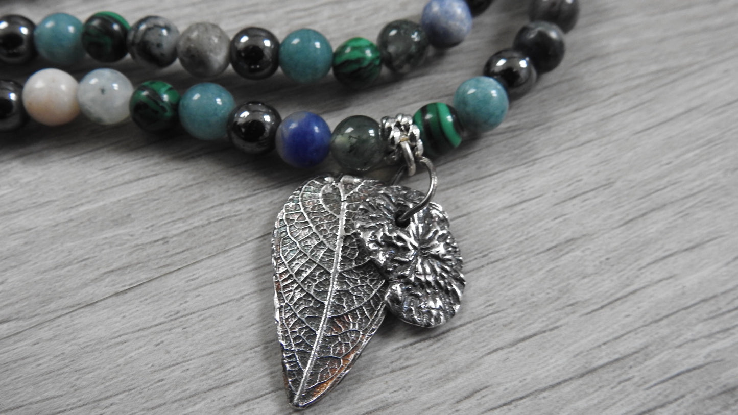 Handcrafted sterling silver hybrid pendant combining leaf and coral textures inspired by Northern Ireland coastlines, front view against white background.