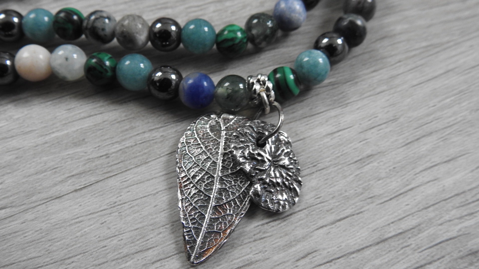 Handcrafted sterling silver hybrid pendant combining leaf and coral textures inspired by Northern Ireland coastlines, front view against white background.