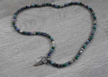 Side profile view of handcrafted sterling silver leaf and coral pendant showing three-dimensional organic form and texture blend.