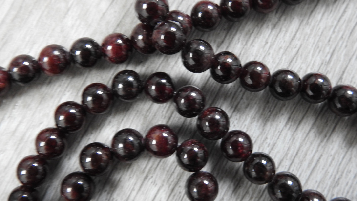 Full view of sterling silver leaf necklace showing chain and pendant combination with garnet stones and Markeaton Park-inspired design.