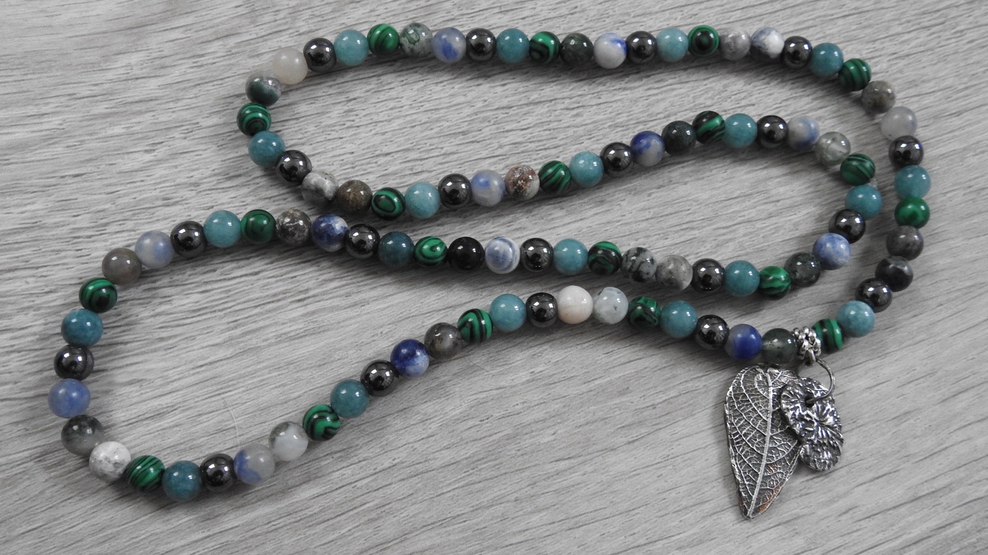 Angled view of sterling silver hybrid pendant highlighting raw textures of nature where woodland meets Atlantic shores.