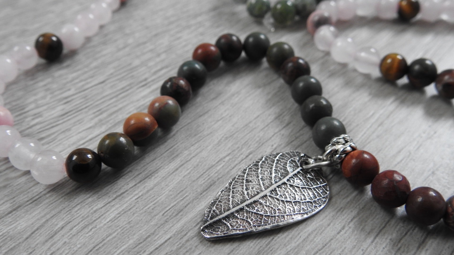 Front view of handcrafted sterling silver leaf pendant with antique silver finish and warm cultural-inspired semi-precious stones.