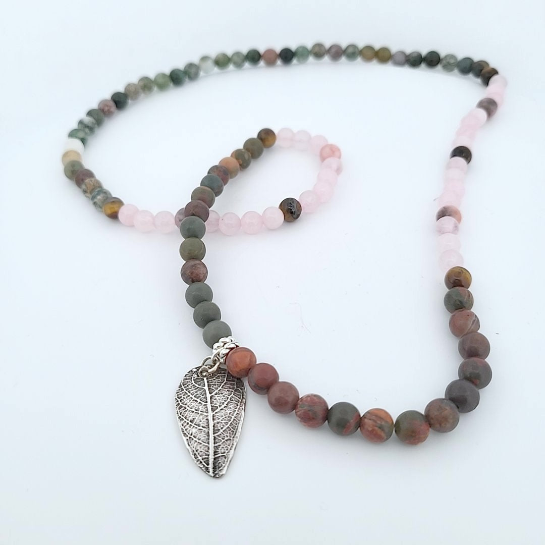 Side profile view of handcrafted sterling silver leaf pendant showing three-dimensional organic leaf form.