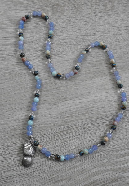 Macro detail of authentic seashell texture impressed into sterling silver pendant showing natural organic coastal patterns.