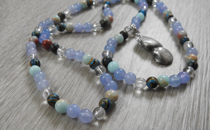 Angled view of sterling silver sea shell pendant showcasing authentic shell texture and ocean-inspired gemstone arrangement.