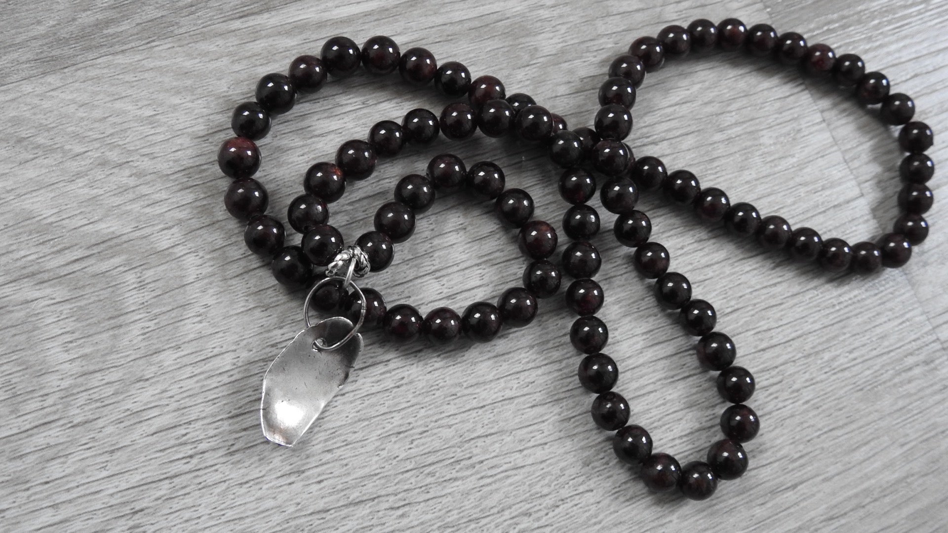 Reverse side of rustic leaf pendant displaying sterling silver back finishing and artisan craftsmanship with antique silver detailing.