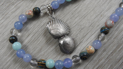 Close-up detail of sterling silver sea shell pendant showing aquamarine, clear quartz, blue snakeskin stone, and blue malachite placement.
